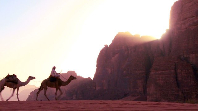 A camel train crosses the Saudi desert in Wadi Rum, Jordan.