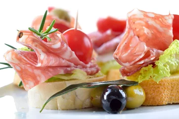 Photo sur Plexiglas Buffet, Bar Partyhäppchen mit feiner italienischer Salami,  Salatblatt und Cherrytomate