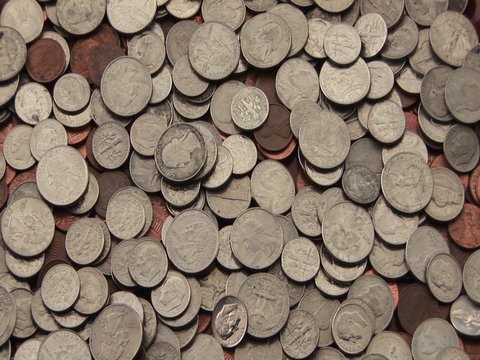 A pile of American coins lies spread out on a surface.
