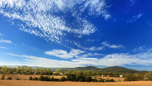 Fototapeta Krajobraz wiejski, góry i chmury.