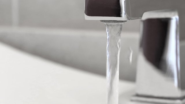 Open faucet in bathroom, water is running
