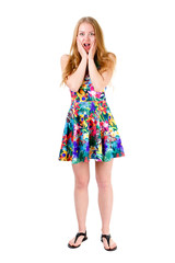 Wondered pretty blonde teenager with wide open eyes and mouth standing and holding hands near her face. Isolated on white background, human emotion, facial expression