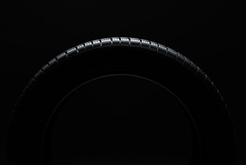 Tire over black background