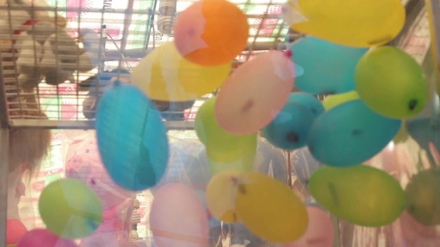 close-up colorful balloon spinning in glass box by blowing machine