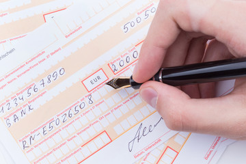 m&auml;nnliche Hand F&uuml;llt &Uuml;berweisungstr&auml;ger