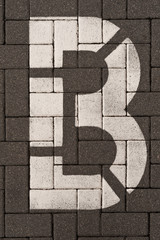 Buchstabe B mit weisser Farbe auf grauen Beton-Pflastersteinen