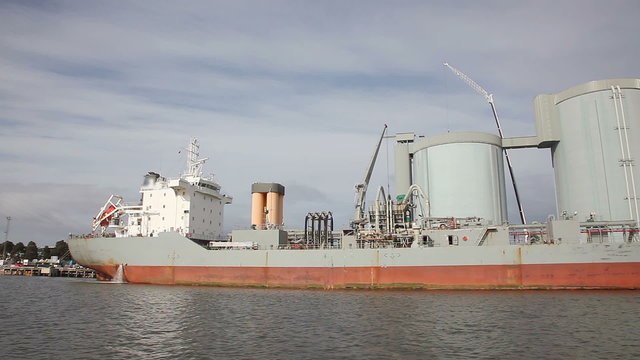 Hyperlapse video of sailing pass a cement carrier loading at a cemet factory
