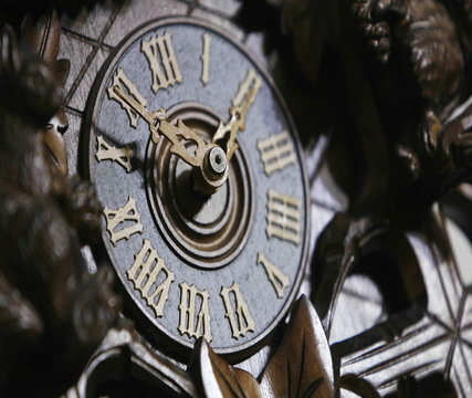The hands of a cuckoo clock advance in this time lapse shot.