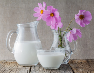 Breakfast concept. Cup of milk on wooden table with flowers