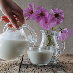 Healthy food concept. Cup of milk on wooden table with flowers