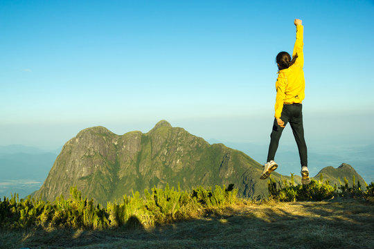 hiker celebrating success on top of a mountain