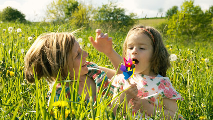 Mutter und Tochter kuscheln und spielen zusammen in einer Frühlingswiese - Teil 14