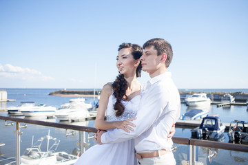 bride and groom on the background of  yacht club, young happy