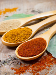 Spice powder on a wooden background. Closeup on paprika, curry and ginger.