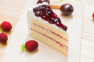 delicious sweet blueberry cheese cake on wooden with strawberry