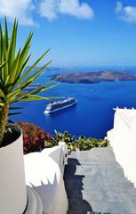 View of the Santorini caldera, seen from the steps of the capital city, Fira. A couple of cruise ships and several boats can be seen in the far.
