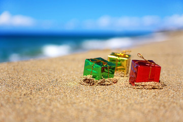 Fototapeta na wymiar Christmas present boxes on tropical beach