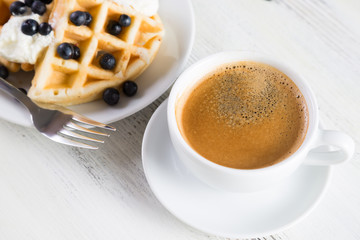 Coffee and Belgian waffles with blueberries. Breakfast