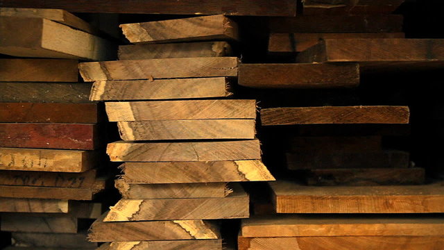 Planks of wood and lumber are stacked vertically.