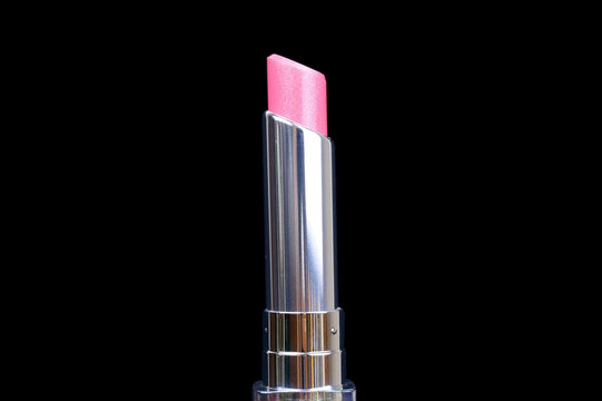One open lipstick isolated on black background