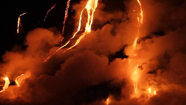 Spectacular nighttime lava flow from a volcano into ocean.