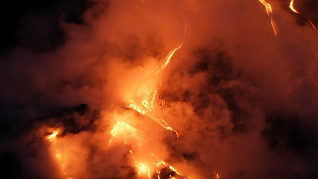 Spectacular nighttime lava flow from a volcano into ocean.