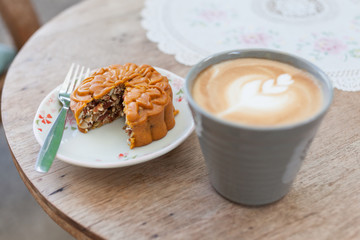 Mooncake with a cup of coffee latte