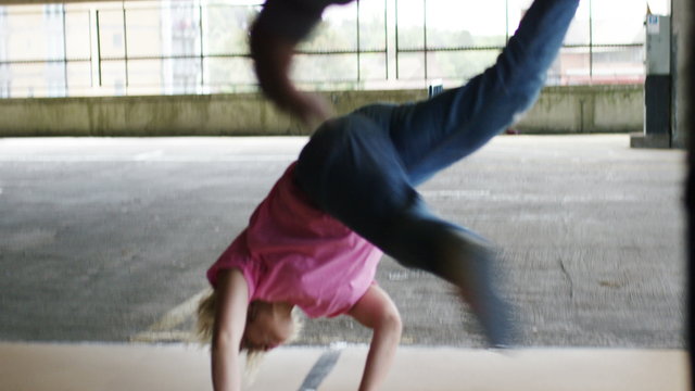 4K Female breakdancer spins on her back and does a handstand, in slow motion, shot on Red Epic Dragon