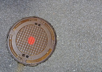 Kanaldeckel mit rotem Punkt