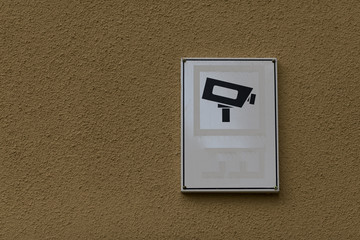 A camera survaillance sign on a wall
