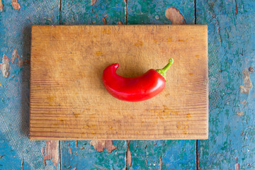 a juicy red peppers on a cutting board on a bright wooden table