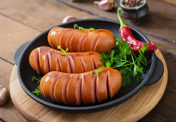 Sausages on the grill pan on the wooden background