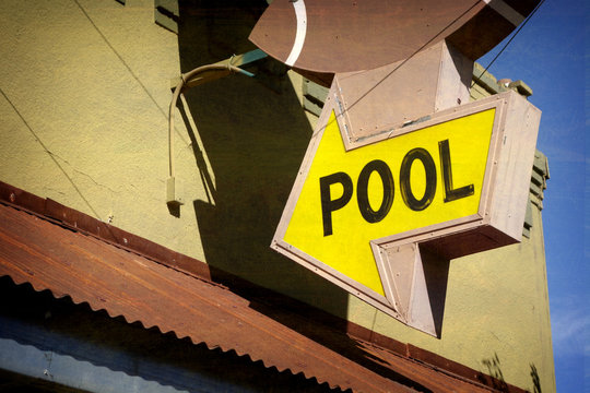 aged and worn vintage photo of pool sign