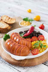 Sausages on the grill with vegetables on a platter