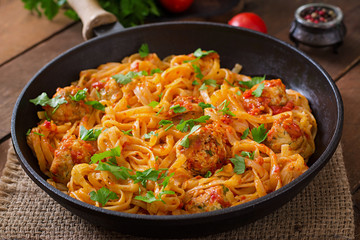 Pasta linguine with meatballs in tomato sauce.