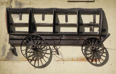 aged and worn vintage photo of old covered wagon on wall