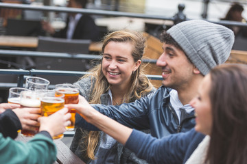 Group of friends enjoying a beer at pub in London