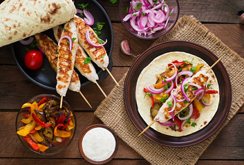 Chicken kebab with grilled vegetables and tortilla wrap. Top view