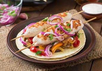 Chicken kebab with grilled vegetables and tortilla wrap.
