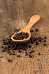 black pepper on wooden spoon