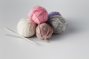 Fototapeta na wymiar Clews of colored yarn with niddle
