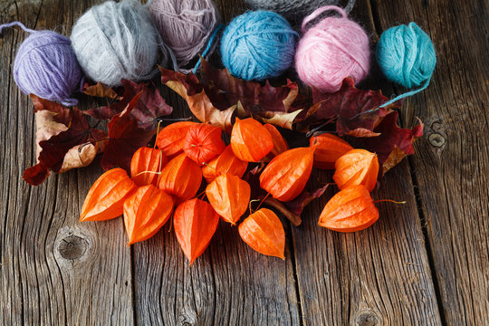 Fall leaves and wool clew  on rustic wooden background