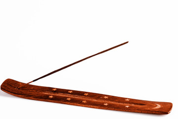 Incense stick on a wooden support on a white background