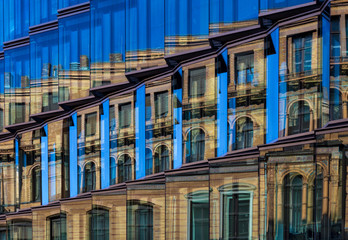 Old house reflected in a glass facade