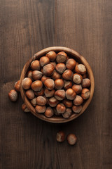 hazelnuts in wooden bowl on the brown table