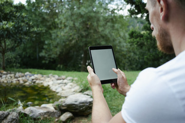 Man using digital tablet PC in the park