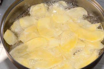 Frying potato chips in deep hot oil