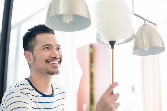 Asian Man Dusting His Home