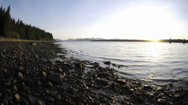 Fast time lapse of the sunset and tide retreating on the beach in Glacier Bay National Park in Gustavus, Alaska.