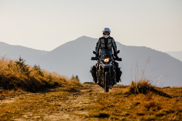 Motorbiker travelling in autumn mountains